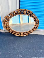 Full view of oval mirror leaning against wall
