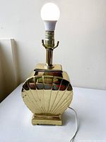 Front view showing brass seashell base, socket and bulb