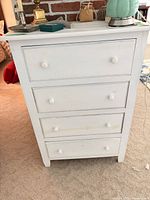 Front view of white 4-drawer dresser showing knobs and finish