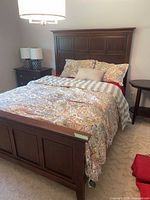Full view of queen bed frame with bedding to show headboard and footboard design