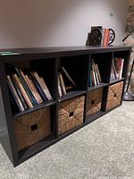 Books arranged in cubby shelf with bookends on top right
