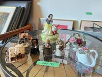 Group shot of all eight figurines on glass table