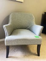 Front view of light grey upholstered lounge chair