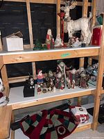 Overall lot on shelving showing reindeer, Santas, candle holder, tree skirt and boxes