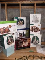 Stack of boxed Department 56 village sets on shelf