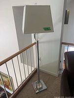 Full view of chrome floor lamp with shade and base