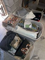 Overview of three storage bins containing assorted pillows and linens