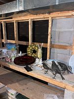 Overview of shelf with wreath, rabbit, chargers, birds, bowls and other items