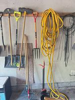 Overview of tools hanging and hose coiled on wall