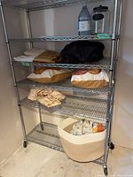 Overview of shelves displaying folded linens and two decorative pillows