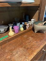 Wide view of cabinet shelf showing assortment of miniature vases, bowls and cups