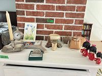 Wide view of all decor items on white shelf against brick wall