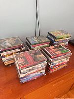 Six stacks of assorted DVDs on dresser