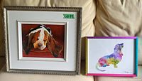 Front view of both framed paintings on couch