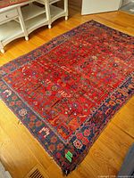 Full view of rug showing red field and border