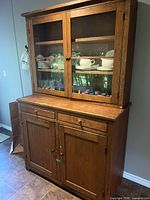 Full view of pine china cabinet showing upper glass doors and lower storage