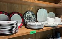 Shelved assortment of plates showing multiple patterns and sizes