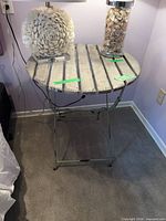 Full view of round side table showing slatted wooden top and metal legs