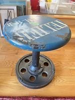 Full view of blue metal side table showing top and base