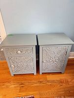 Front view of both blue carved wood side tables