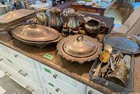 Group shot of covered dishes, pitchers, goblets, tray, flatware basket