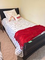 Full view of assembled twin bed showing headboard, bedding for scale