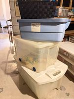 Stack of blue bin on two clear Rubbermaid bins with basket inside blue bin