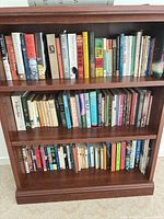 Full view of three-shelf bookcase showing quantity and variety of books