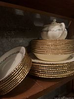 Stack of bowls and plates showing gold trim and floral pattern