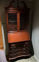 Full view of mahogany-style secretary desk against wall