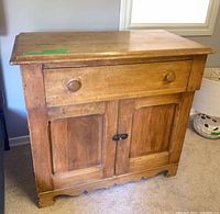 Front view of wooden cabinet showing drawer and doors