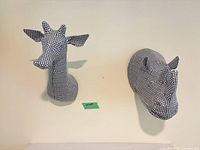 Frontal view of both houndstooth paper mache wall busts mounted on wall