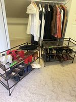 Two metal racks holding multiple pairs of women’s shoes