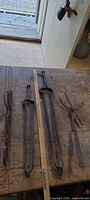 All three forged iron fireplace tools laid out with ruler for scale