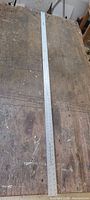 Full view of 72-inch metal ruler on workbench