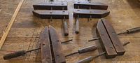 Four wooden handscrew clamps on workbench