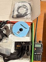 Radio with accessories in packaging including USB cable, CD, charger, strap