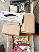 Overview of lot in tote showing sprayer, paper wipers box, masking paper rolls, and hand tools