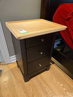 Front view of dark brown nightstand with light wood top