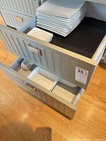Stacked square dinner and salad plates in drawer