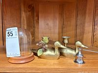 Pair of brass duck candle holders, glass cloche with wood base, metal snuffer displayed on shelf