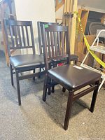Front angled view of three folding chairs showing frames, seats, and backs