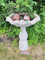 Full view of birdbath with bricks and hose in bowl