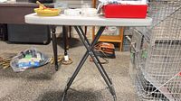 Full view of table front showing resin top and X-frame legs