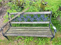 Full front view of cast iron and wood garden bench outdoors