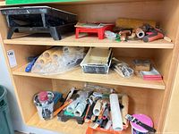 Shelf with black roller tray, red tray, roller covers, brushes, tools