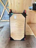 Front view of plywood mobile base showing frame and casters