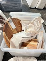 Tote containing round wooden board, wooden board, white dishes