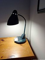 Full view of lamp on table showing base, neck, and shade