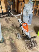 Full view of Stihl tiller showing tines, wheels and handle